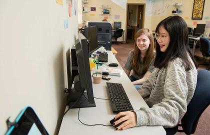 Two female students sitting at a computer station